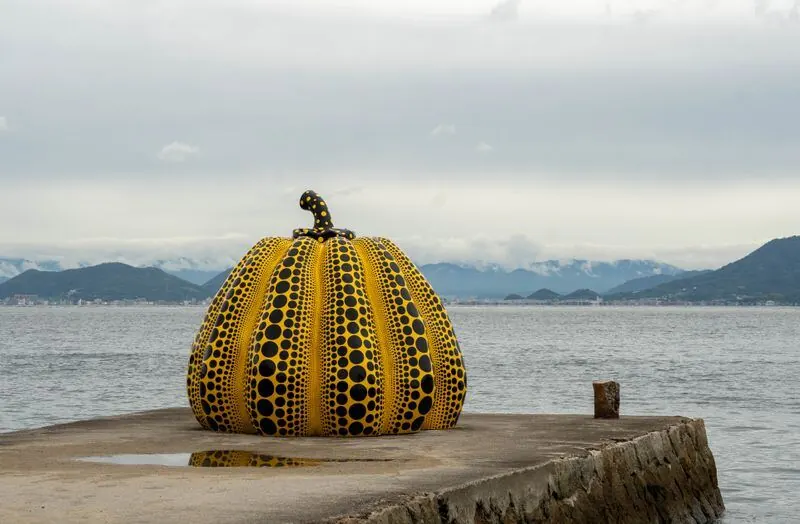 Yellow pumpkin sculpture on a pier on Naoshima